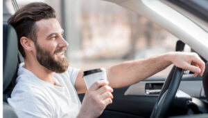 man driving with cup of coffee